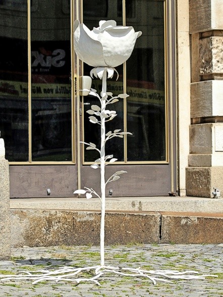 Vor dem Haupteingang des Justizpalasts steht unverdrossen eine zierlich geschmiedete weiße Rose (Foto: Achim Wigand)
