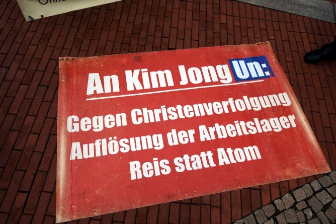 Ein Plakat der kleinen Demogruppe, die jeden Donnerstag vor dem Gebäude auftritt (Foto: Michael Bussmann und Gabriele Tröger)
